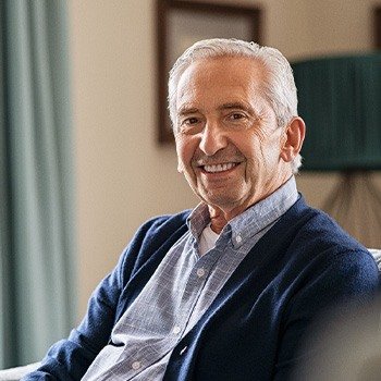 Older man sitting on couch smiling