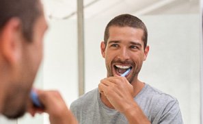 Invisalign patient in Kent brushing teeth