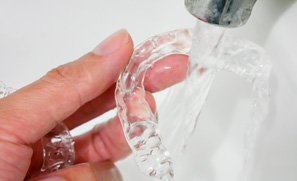 Patient in Kent cleaning their Invisalign trays