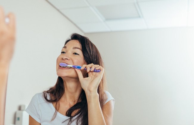 Woman brushing her teeth in bathroom