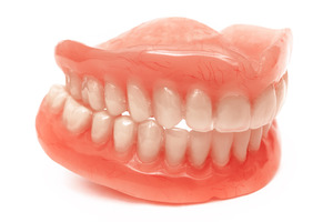 Two full dentures sitting on white surface